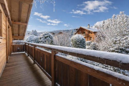 a balcony with snow covered trees and a house at Alpine Luxury Chalet Pool & Jacuzzi in Cordon