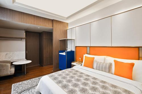 una camera con un grande letto con testiera arancione di Fortune Select Siliguri a Binnāguri