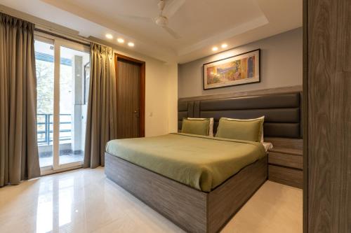 una camera da letto con un letto e una grande finestra di Liv Regalia - 1BHK Suites Near Huda CIty Centre a Gurgaon