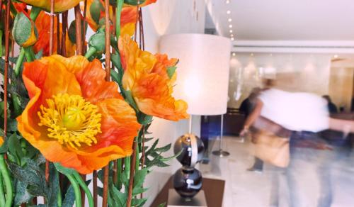 a vase filled with orange flowers on a table at Hotel Lux Fatima in Fátima