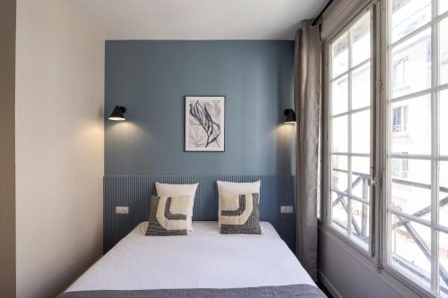a bedroom with a bed and a window at Air-conditioned and cozy haven in Le Pré-Saint-Gervais