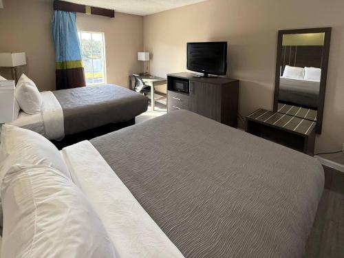 een hotelkamer met twee bedden en een televisie bij Quality Inn Ormond Beach - Daytona in Ormond Beach