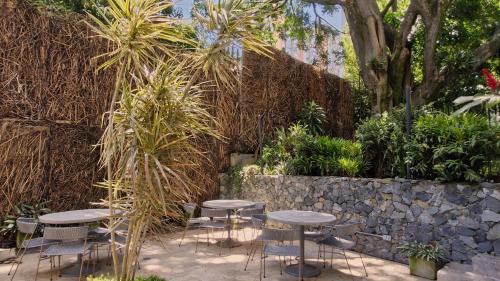 a group of tables and chairs in a garden at V Grand Hotel, a member of Radisson Individuals in Medellín