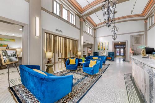 a lobby with blue chairs and a bar at Hotel 1914 - Historic Alamo Riverwalk, an Ascend Collection Hotel in San Antonio