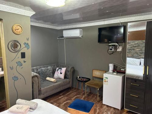 a small room with a couch and a bed at Lake boutique hotel empire in Thohoyandou
