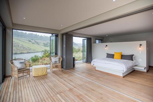 a bedroom with a bed and a large window at Star Dam Lodges in Dargle