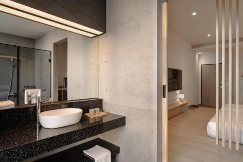 a bathroom with a sink and a mirror at HOYU INN's in T'ien-liao