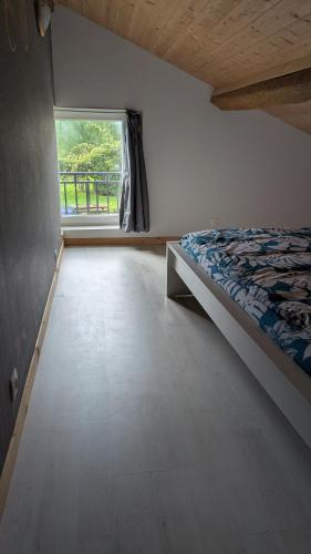 a bedroom with a bed and a large window at Independent studio in nature in Saint-Valérien