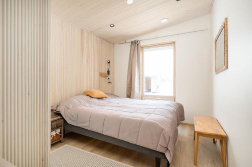 una piccola camera da letto con un letto e una finestra di Villa Naali E a Kilpisjärvi