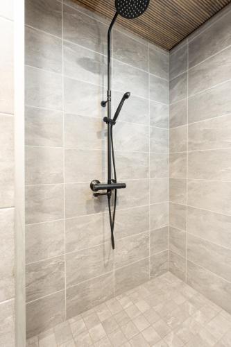a shower with a shower head in a bathroom at Villa Naali E in Kilpisjärvi