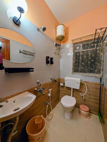 a bathroom with a white toilet and a sink at Ketaki Homestay in Shānti Niketan