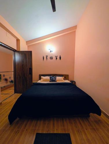 a bedroom with a large black bed in a room at Ketaki Homestay in Shānti Niketan