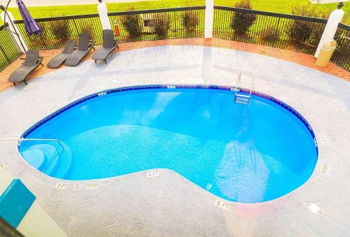 a large blue swimming pool with chairs around it at Baymont by Wyndham Port Wentworth in Port Wentworth