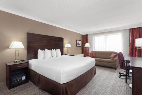 een hotelkamer met een groot bed en een bank bij Wyndham Minneapolis South Burnsville in Burnsville