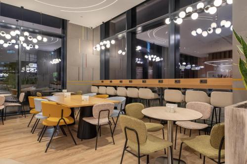 un ristorante con tavoli e sedie e un bar di Hampton By Hilton Batumi Center a Batumi