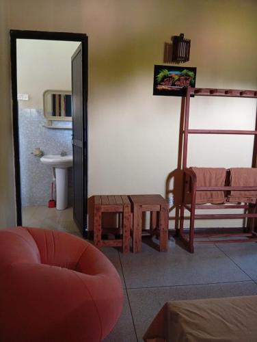 a living room with a chair and a mirror at Samee Villa & Hostel Airport in Seeduwa