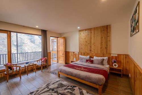 a bedroom with a bed and a balcony at SaffronStays Tirthan House - Balcony View in Bandal