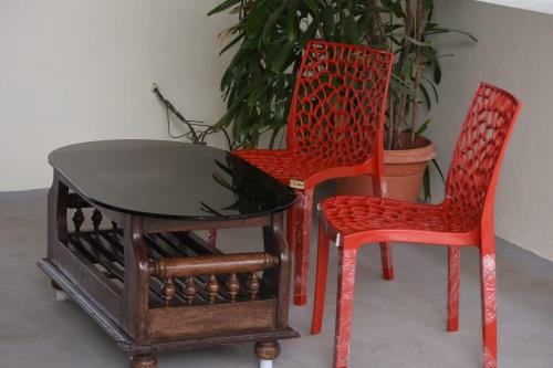 twee stoelen en een tafel en een tafel en twee stoelen bij Aakruthi Homestay in Davangere