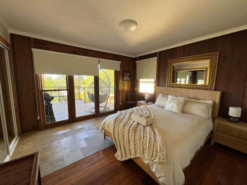 a bedroom with a large bed and a window at Christophers Cottage in Bilpin