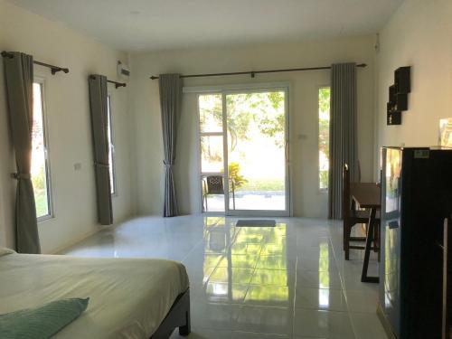 a bedroom with a bed and a sliding glass door at Lanta Vacation House in Ko Lanta