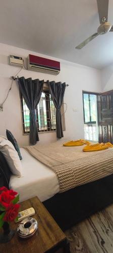 a bedroom with two beds with curtains and a table at Morni Home's morjim in Morjim