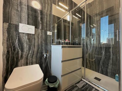 a bathroom with a toilet and a shower at Suite Rossini - 100mq con parcheggio gratuito in Alessandria