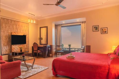 een slaapkamer met een rood bed en een woonkamer bij The Horizon Villa Dharamshala in Dharmsala