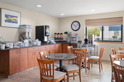 a restaurant with a counter and tables and chairs at Super 8 by Wyndham Hagerstown I-70 in Hagerstown