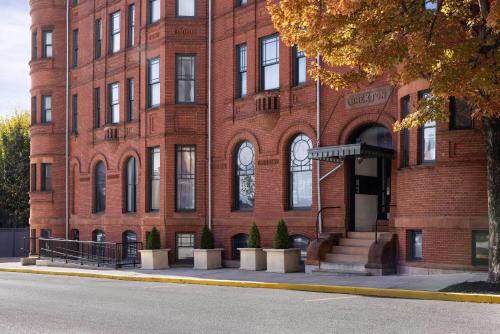 a red brick building with potted plants in front of it at Hotel Brexton, Trademark Collection by Wyndham in Baltimore