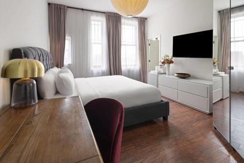 a bedroom with a bed and a desk and a television at Hotel Brexton, Trademark Collection by Wyndham in Baltimore