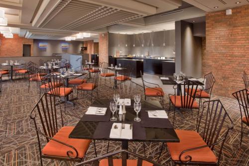 a restaurant with tables and chairs in a room at Wyndham Gatineau-Ottawa & Conference Centre in Gatineau
