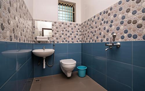 a blue bathroom with a toilet and a sink at RAIAl DWELLING PLACE in Calangute