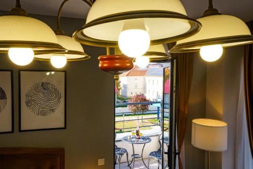 eine Gruppe von Leuchten, die von einer Decke hängen in der Unterkunft Hotel Fantazia Oradea - Self Check In & Out in Oradea