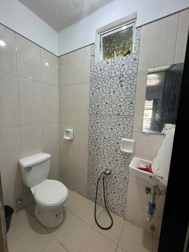 a bathroom with a toilet and a sink at KNB West Villa Inn by SMS Hospitality in Bolinao