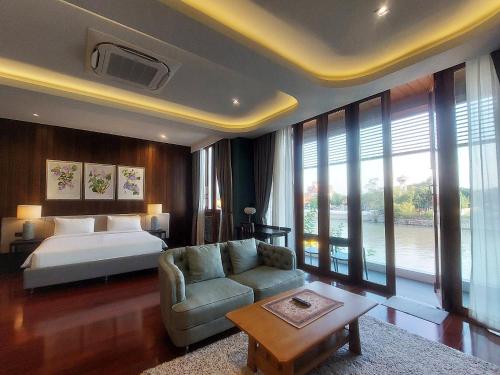 una camera da letto con un letto, un divano e un tavolo di Baan Veanglhek Residence a Phra Nakhon Si Ayutthaya