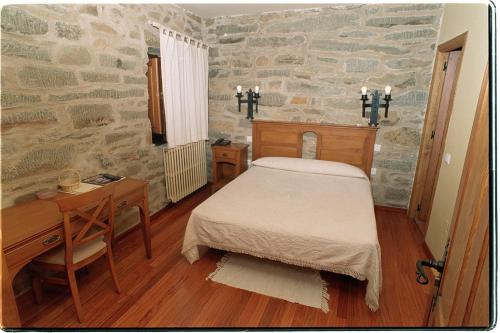 1 dormitorio con cama, mesa y escritorio en Hotel Rural El Rincón de Trefacio en Trefacio