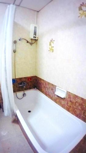 a bath tub in a bathroom with a shower at P.A. Ville Hotel in Nakhon Sawan