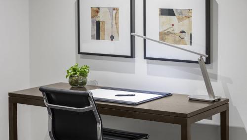 a desk with a chair and a laptop on it at Flagstaff Gardens Hotel Melbourne in Melbourne