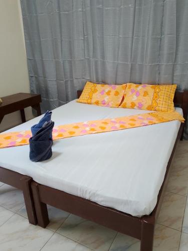 two beds with yellow pillows and a white mattress at Nory's Tourist Inn in San Vicente