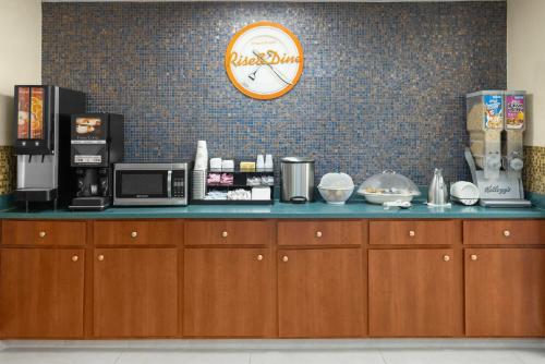 een aanrecht in een koffiehuis met een klok aan de muur bij Howard Johnson by Wyndham Savannah GA in Savannah