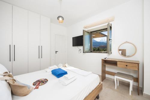 a bedroom with a bed and a desk and a mirror at Villa Castillo Ena in Agios Nikolaos