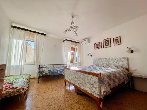 een slaapkamer met twee bedden en een raam bij L'ENCANTO DE LUNA -Una Casa Autentica Comacchiese in Comacchio