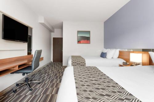 Giường trong phòng chung tại Microtel Inn & Suites Sault Ste. Marie