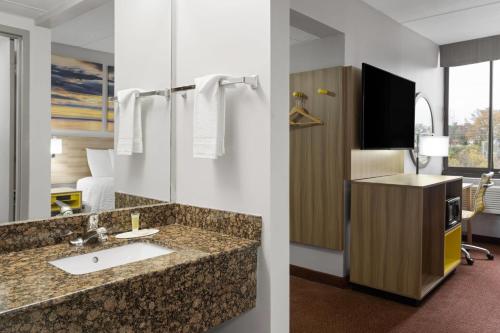 a hotel bathroom with a sink and a tv at Days Inn by Wyndham Hagerstown I-70 in Hagerstown