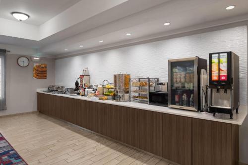 a restaurant with a counter with a refrigerator at La Quinta by Wyndham Gallup in Gallup