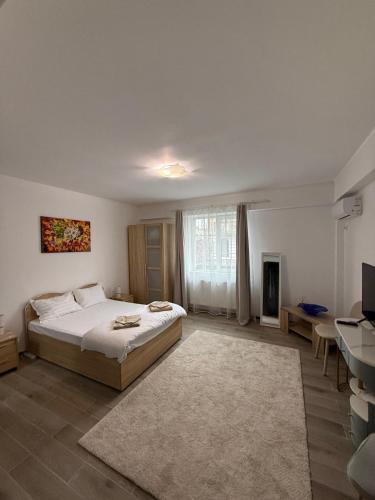 a bedroom with a bed and a desk and a television at Parlament Residence in Bucharest