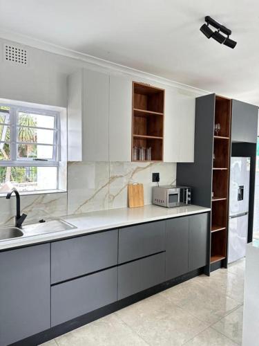 a kitchen with white cabinets and a sink at Lux City Haven in Cape Town