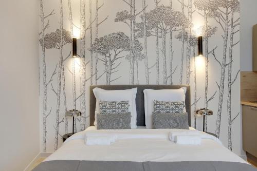 een slaapkamer met een bed met bomen aan de muur bij Refined air-conditioned studio in Neuilly in Neuilly-sur-Seine