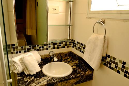 y baño con lavabo y espejo. en Residencial Pantanal Santa Cruz, en São Paulo