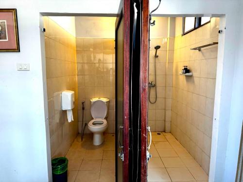 a bathroom with a toilet and a stall with a shower at Palette Bangkok Natural Resort and Spa in Bangkok